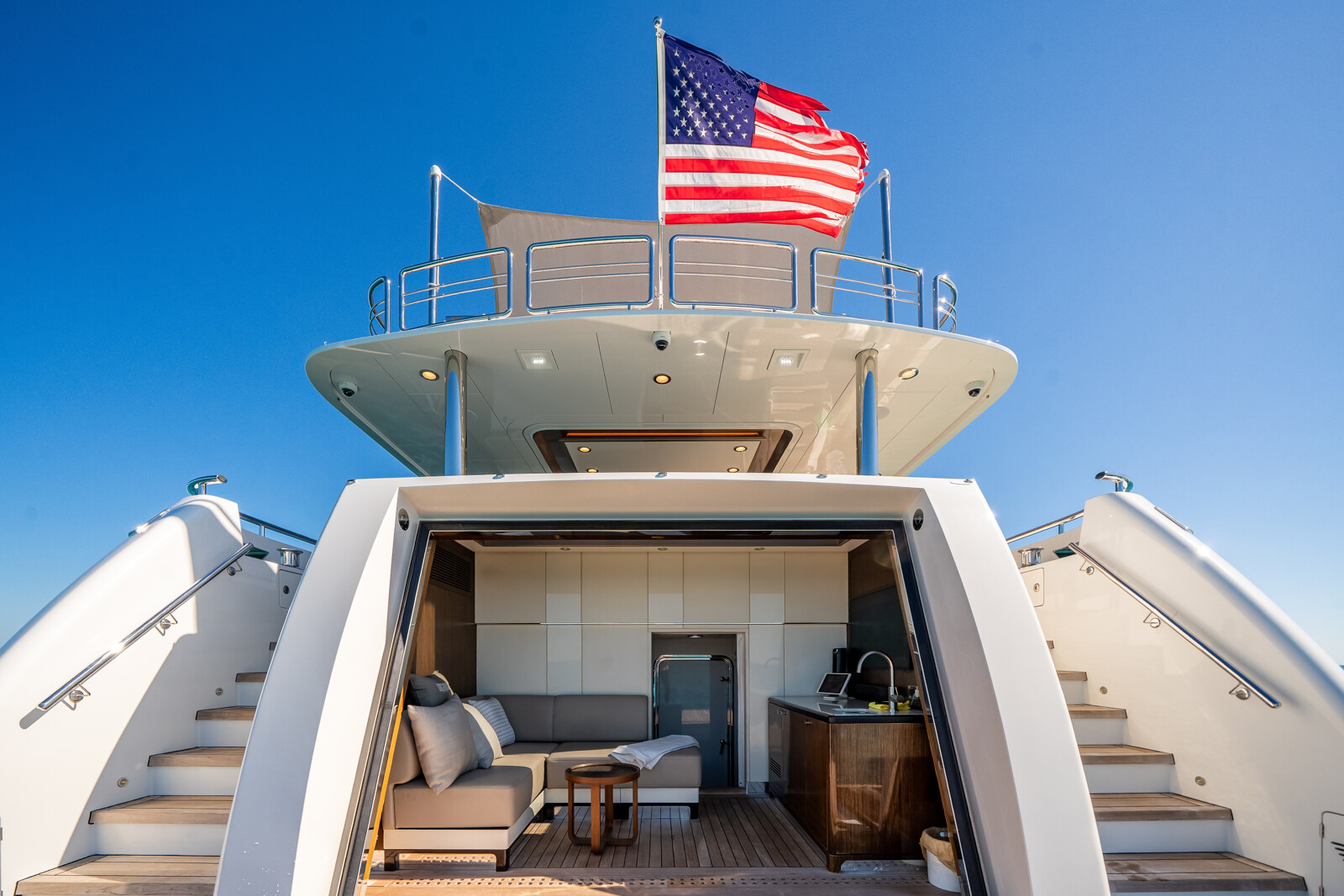 DREAMS beach club with flip-down transom door open at the waterline, US flag above